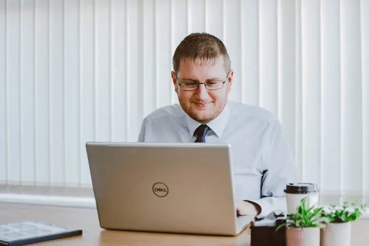 What is the difference between a job and a career - A man working using a laptop while smiling.